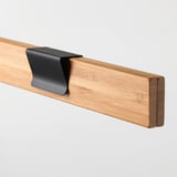 Dřevěný věšák na plakáty s černým klipem, který ukazuje vysoce kvalitní řemeslné zpracování a robustní design.