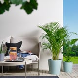 Balkon se zelenými rostlinami v odolných květináčích VITLÖK a moderním nábytkem.