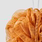 Orange mesh body puff for exfoliation, hanging loop visible, finer mesh detail noticeable.