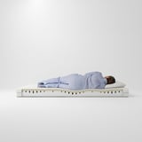 A person sleeping on ÅBYGDA, a blue, medium-firm foam mattress. It two layers for comfort and support, with a washable cover and a 10-year guarantee.