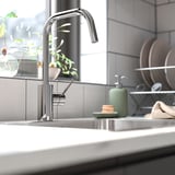 ÄLMAREN chrome faucet with high-arc design over sink.