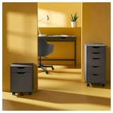 Modern home office: ALEX drawers, desk, yellow walls, lamp, plant.