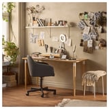 Home office with ANFALLARE desk, chair, and decorated wall.