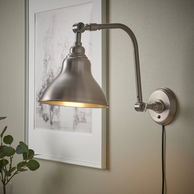 A brushed silver ANKARSPEL lamp with a bell-shaped shade and adjustable arm, ideal for reading.