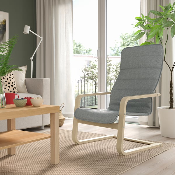 Modern living room with ÅRSUNDA chair, window, plants, pillows, coffee table.