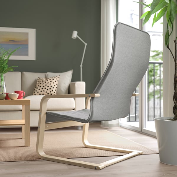 Modern living room with ÅRSUNDA armchair, sofa, lamp, large window, and plant.