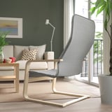 Modern living room with ÅRSUNDA armchair, sofa, lamp, large window, and plant.