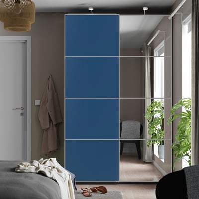 Mirrored sliding closet doors for outfits & style, adding depth to bedroom.