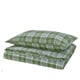 Green plaid pillows and blanket set, made from recycled cotton. Layers of fabric in a chequered pattern, folded neatly.