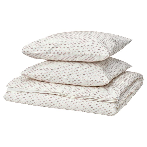 Three stacked pillows, beige with small orange patterns, made from 100% cotton.