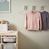 Kids clothing hangers in pastel colors, designed with non-slip surfaces and safe edges, displayed with kids clothes.
