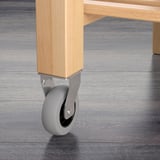 Close-up of wooden furniture caster. Durable beech wheel, silver metal base.