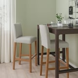 BERGMUND stools at wooden counter with coffee maker, cups & plants. Tall, cushioned, light grey & wood.