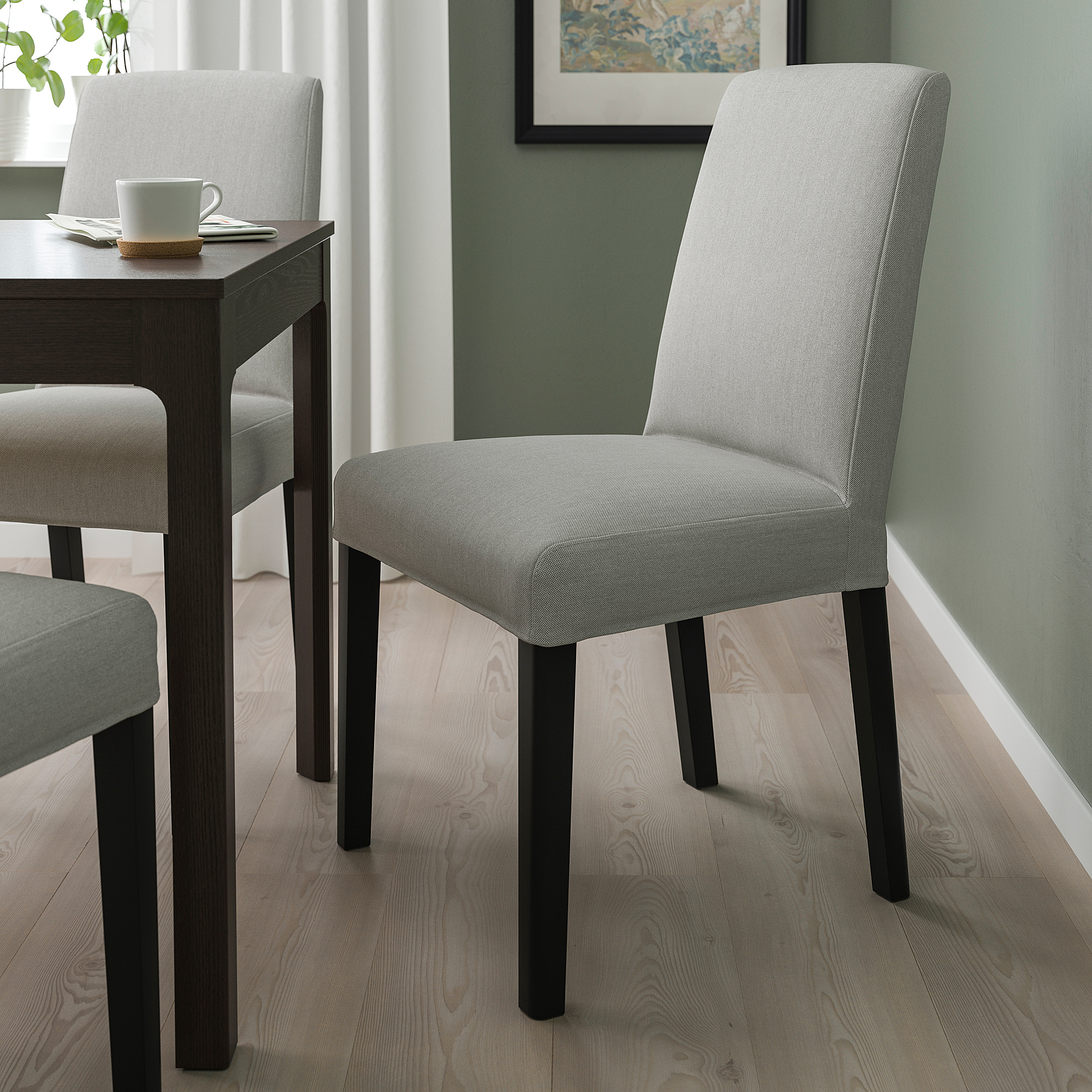 BERGMUND chair, light grey fabric, black legs, high back, by wooden table.