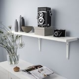 White wall shelf displays cameras and vases. Held by metal brackets.