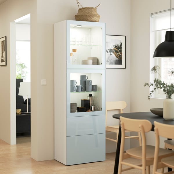 Modern living room with blue BESTÅ cabinet and dishes, between dining table and chair, under black pendant lamp.