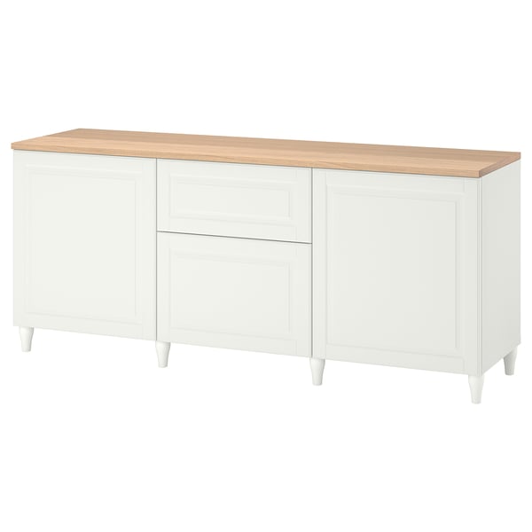 A white BESTÅ sideboard with wooden top, four cabinets, and two drawers, supported by wooden legs.