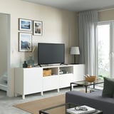 Modern living room with BESTÅ tv bench, grey sofa, & glass door.