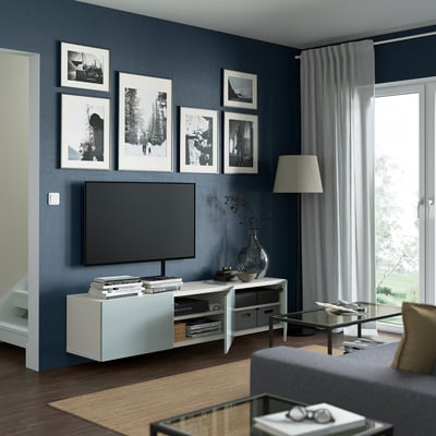 Modern living room with BESTÅ tv bench, flat-screen tv, and glass coffee table.