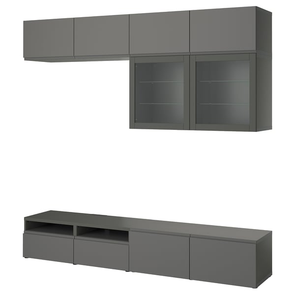 Modern dark gray BESTÅ tv unit: wall-mounted shelves, glass doors, and low cabinet with drawers, sleek design.