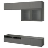 Modern dark gray BESTÅ tv unit: wall-mounted shelves, glass doors, and low cabinet with drawers, sleek design.