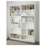 White BILLY bookshelf with multiple adjustable shelves, housing various books and items, securely anchored to the wall.