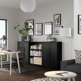 Modern home office with BILLY bookcase, desk, plant, art, sofa, and lamp.