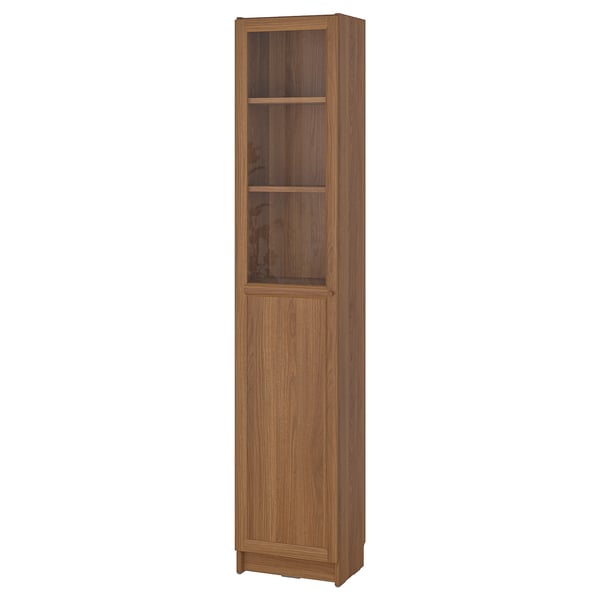 A tall wooden BILLY bookcase with two glass doors, featuring a natural finish and adjustable shelves.