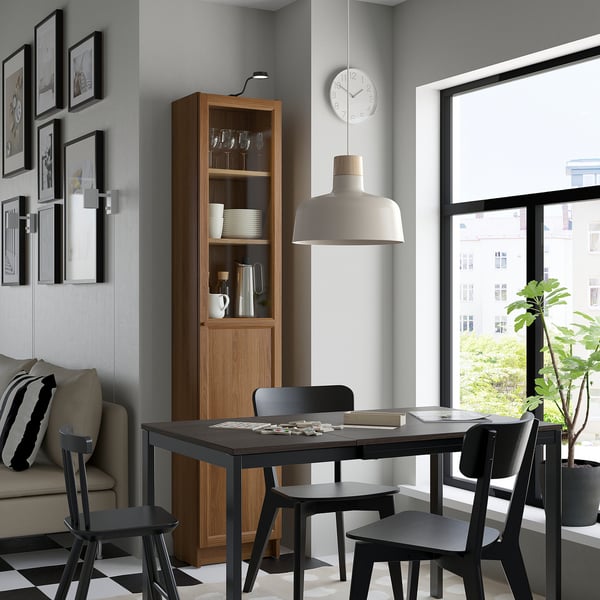 Cozy dining space with BILLY bookcase, black chairs, table, and decor.