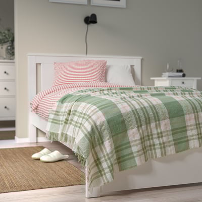 Green & off-white BISKOPSMÖSSA throw blanket, eco-friendly, on bed.