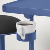 Blue laptop stand holds white coffee cup.