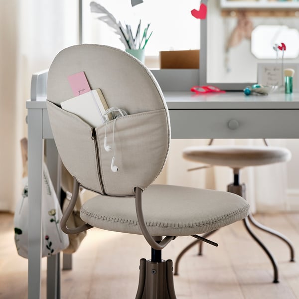 Home office setup: BJÖRKBERGET chair in beige, padded, swivel design, with storage pocket.