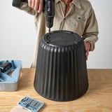 Drilling BJÖRNBAMBU pots for plant drainage.