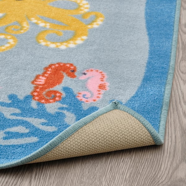 A colorful underwater-themed rug with sea creatures, featuring a non-slip backing for safety.