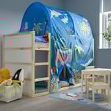 Blue rug with sea creatures in kids room. Nearby, a bunk bed with underwater tent, table, and toy bin.