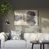 Modern living room with BLODFLÄDER artwork, white couch, and plants.