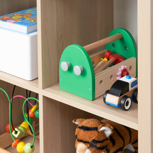 A wooden toy toolbox on a shelf, containing colorful tools and wheels, designed for childrens imaginative play and motor skill development.