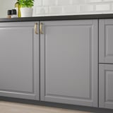 Grey kitchen cabinet with gold handles, smooth lacquered finish, easy to clean.