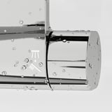 Stainless steel shower mixer with full spray hand shower, droplets on surfaces.
