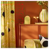 Yellow curtains, orange wall; sideboard, pillow