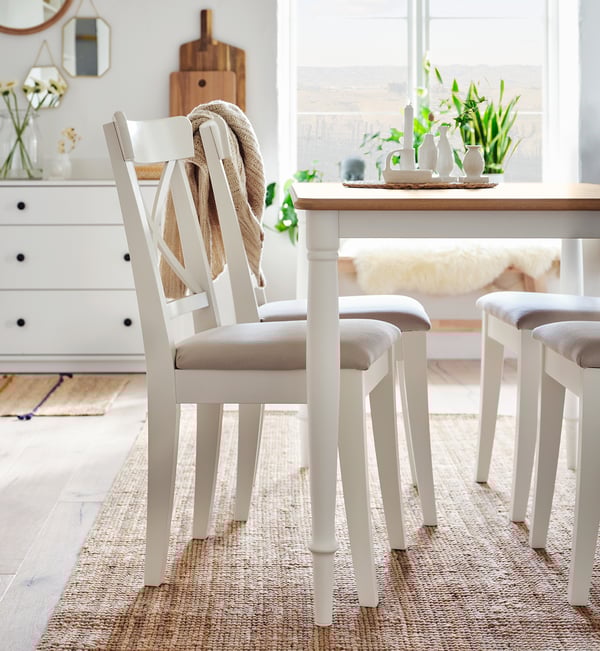 White DANDERYD dining set with oak top table, featuring four upholstered chairs in light beige fabric.