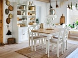 Bright dining room with DANDERYD set, oak table, cushioned chairs, beige covers, white cabinet, plants, and wall decor.