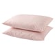 Two light pink cotton pillows stacked neatly.
