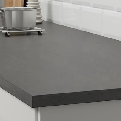 Dark grey kitchen worktop with a metal container and utensils, designed to be durable and easy to clean.