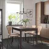 Modern dining room with EKEDALEN extendable table surrounded by woven chairs, sleek cabinetry, and greenery, featuring a stylish, minimalist design.