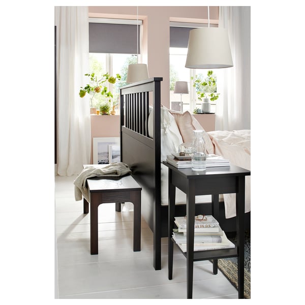 Modern bedroom with black EKEDALEN furniture, soft natural light, and white bedding.