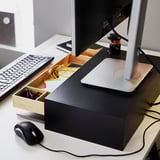 Workstation with monitor stand, keyboard, mouse, and organized desk drawers.