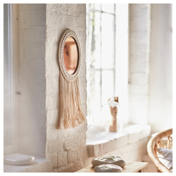 ENERGISKOG wall decor, a round mirror with beige macramé. It hangs on a white wall near a window, giving a warm, cozy look.
