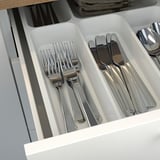 Silverware drawer organizer with compartments for forks, knives, and spoons.