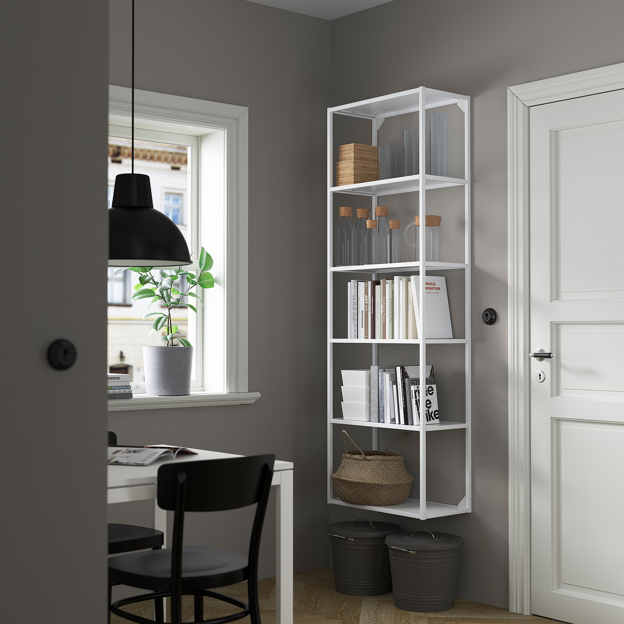 Minimalist office: ENHET bookshelf with books, jars, and basket, between desk and white door.